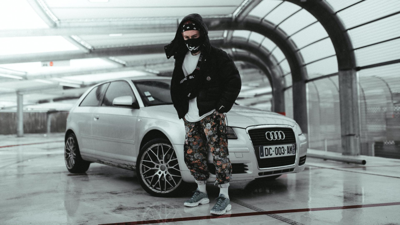 This time he is standing in front of the car.